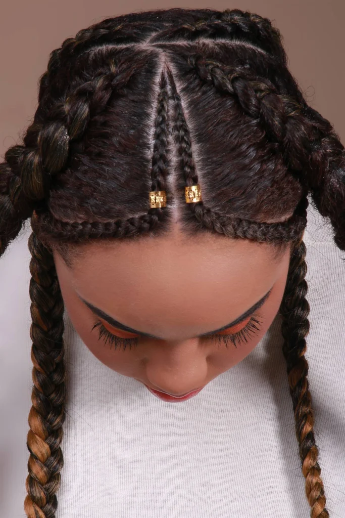 Vista superior de um penteado com risca central e tranças, com o couro cabeludo visível.